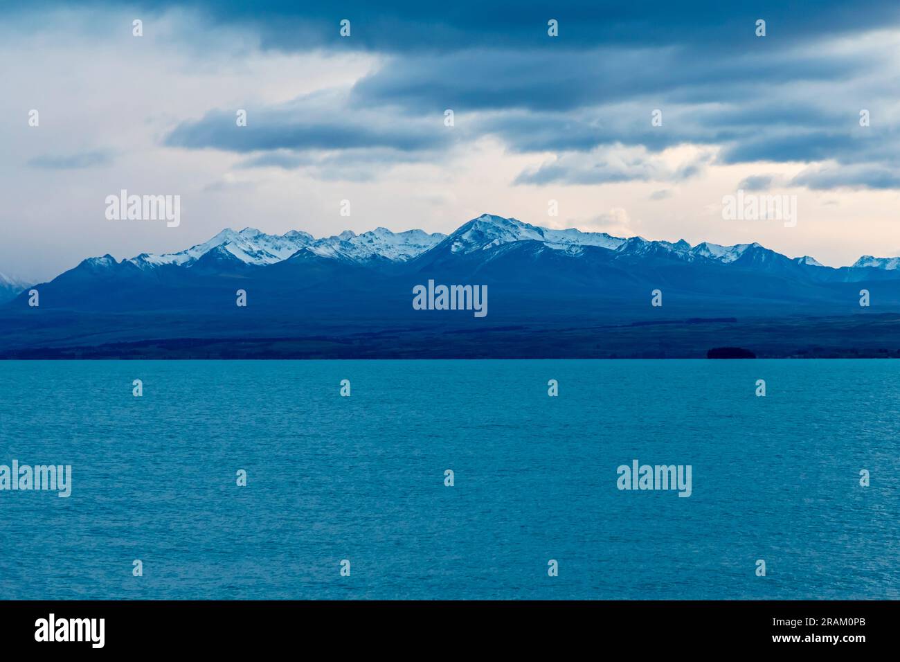 Fotografa il lago Pukaki la mattina presto in una giornata nuvolosa con montagne innevate sullo sfondo dell'Isola del Sud della nuova Zelanda Foto Stock