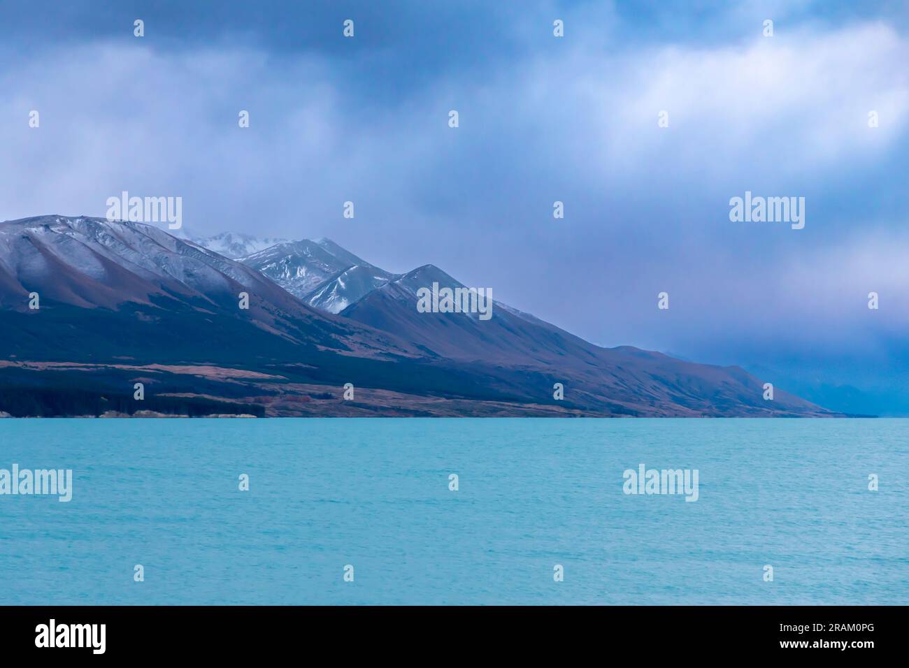 Fotografa il lago Pukaki la mattina presto in una giornata nuvolosa con montagne innevate sullo sfondo dell'Isola del Sud della nuova Zelanda Foto Stock