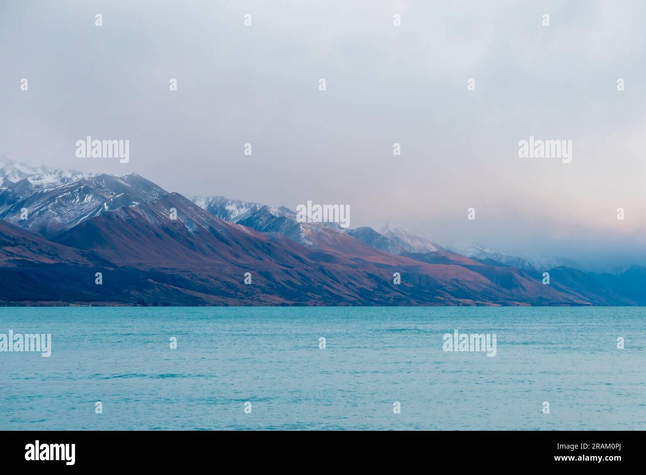 Fotografa il lago Pukaki la mattina presto in una giornata nuvolosa con montagne innevate sullo sfondo dell'Isola del Sud della nuova Zelanda Foto Stock