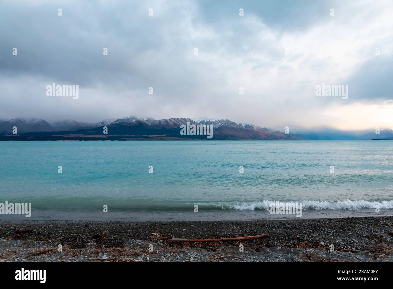 Fotografa il lago Pukaki la mattina presto in una giornata nuvolosa con montagne innevate sullo sfondo dell'Isola del Sud della nuova Zelanda Foto Stock