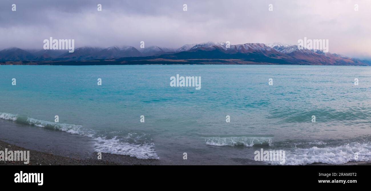 Fotografa il lago Pukaki la mattina presto in una giornata nuvolosa con montagne innevate sullo sfondo dell'Isola del Sud della nuova Zelanda Foto Stock