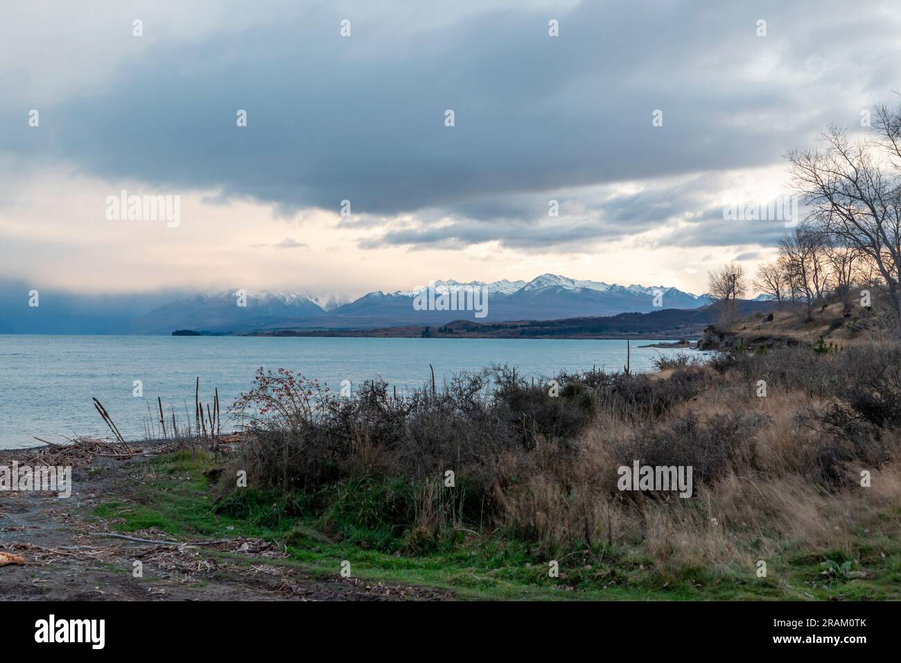 Fotografa il lago Pukaki la mattina presto in una giornata nuvolosa con montagne innevate sullo sfondo dell'Isola del Sud della nuova Zelanda Foto Stock