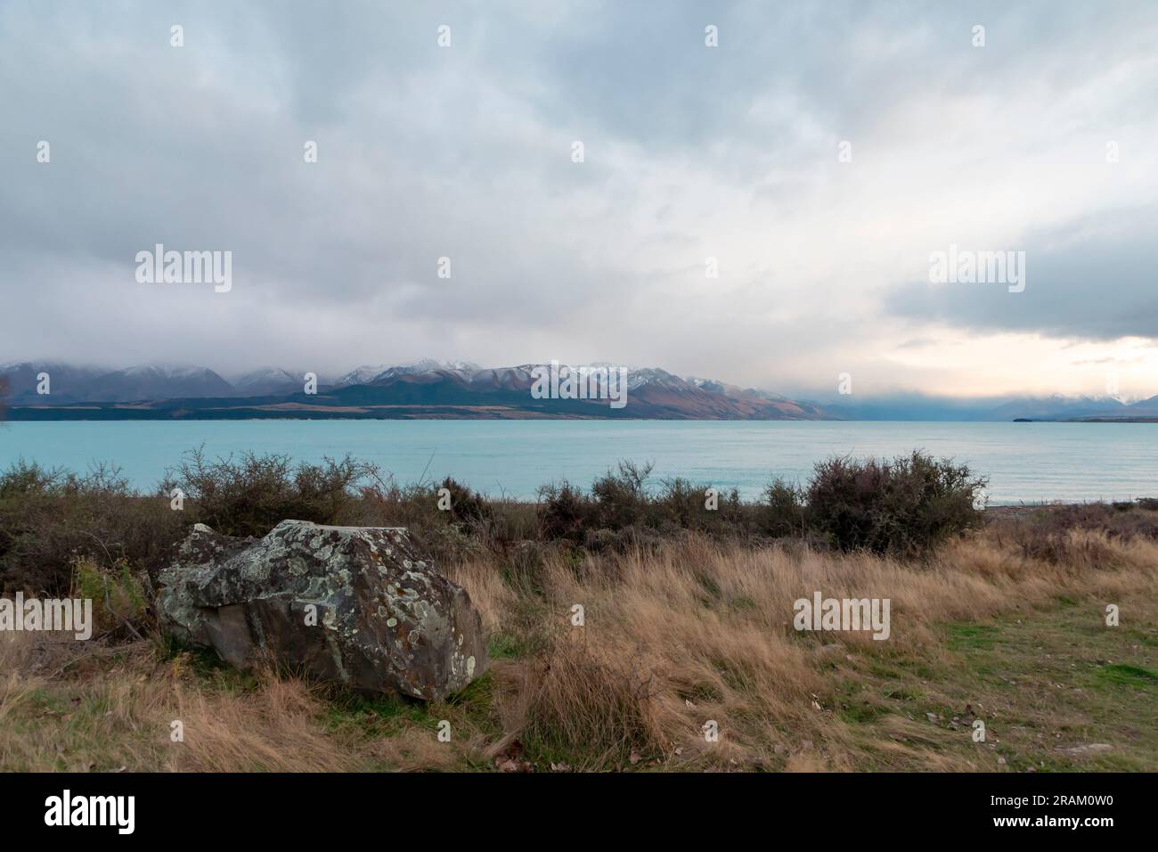 Fotografa il lago Pukaki la mattina presto in una giornata nuvolosa con montagne innevate sullo sfondo dell'Isola del Sud della nuova Zelanda Foto Stock