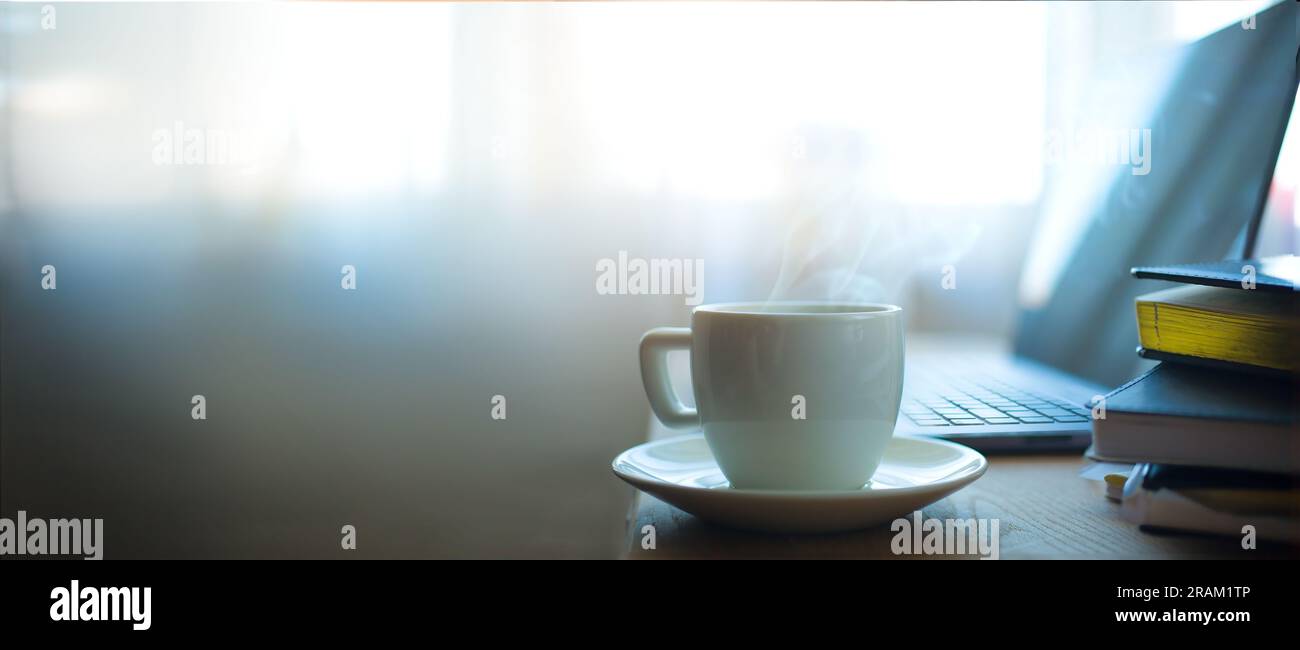 Moderno ambiente di lavoro con computer portatile, tazza da caffè e forniture per ufficio Foto Stock