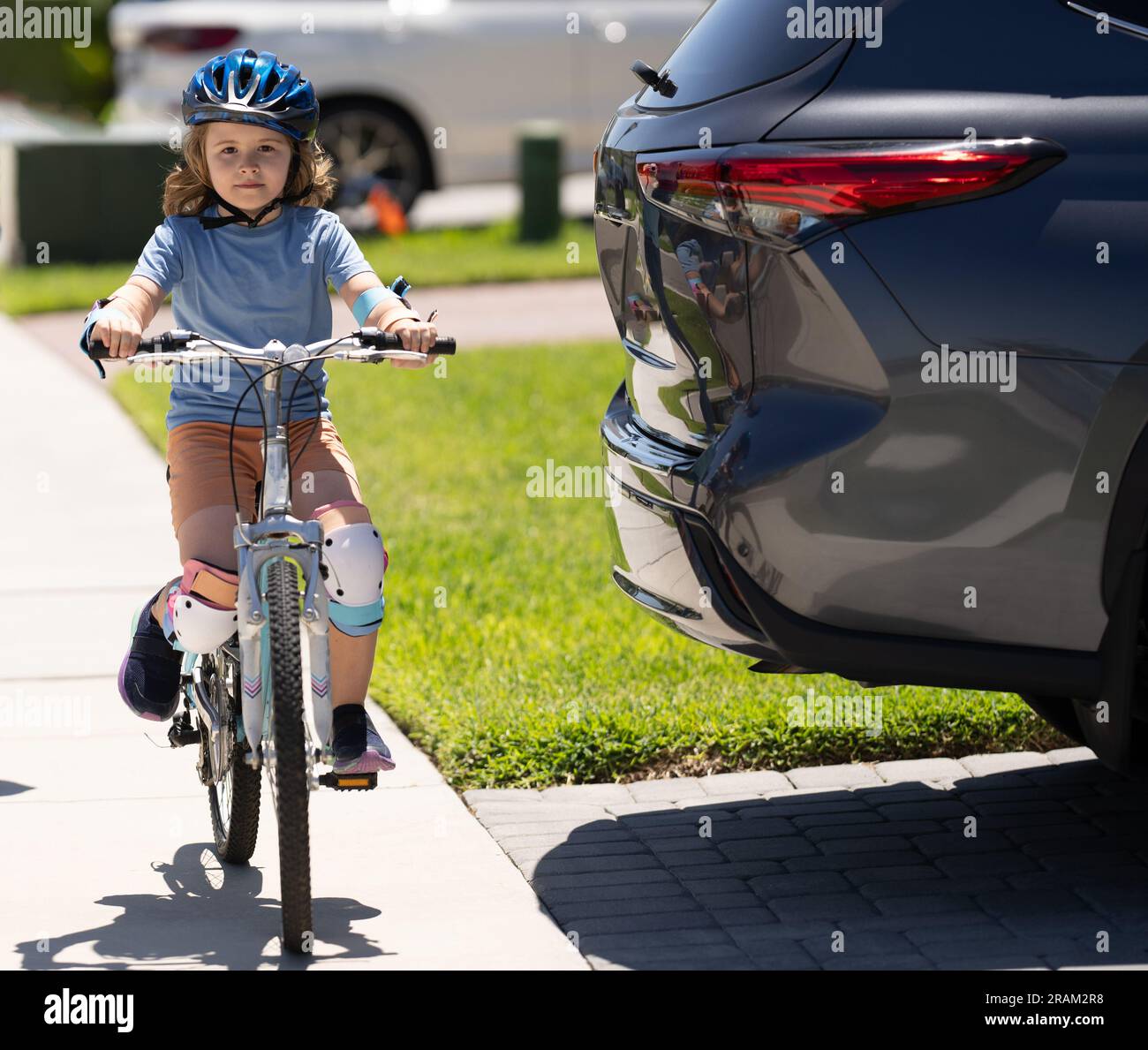 i bambini viaggiano in bicicletta a bordo di un'auto pericolosa. regole stradali pericolose per i bambini. Con prudente eccitazione. educazione alla sicurezza stradale. ciclista per bambini in bicicletta vicino Foto Stock