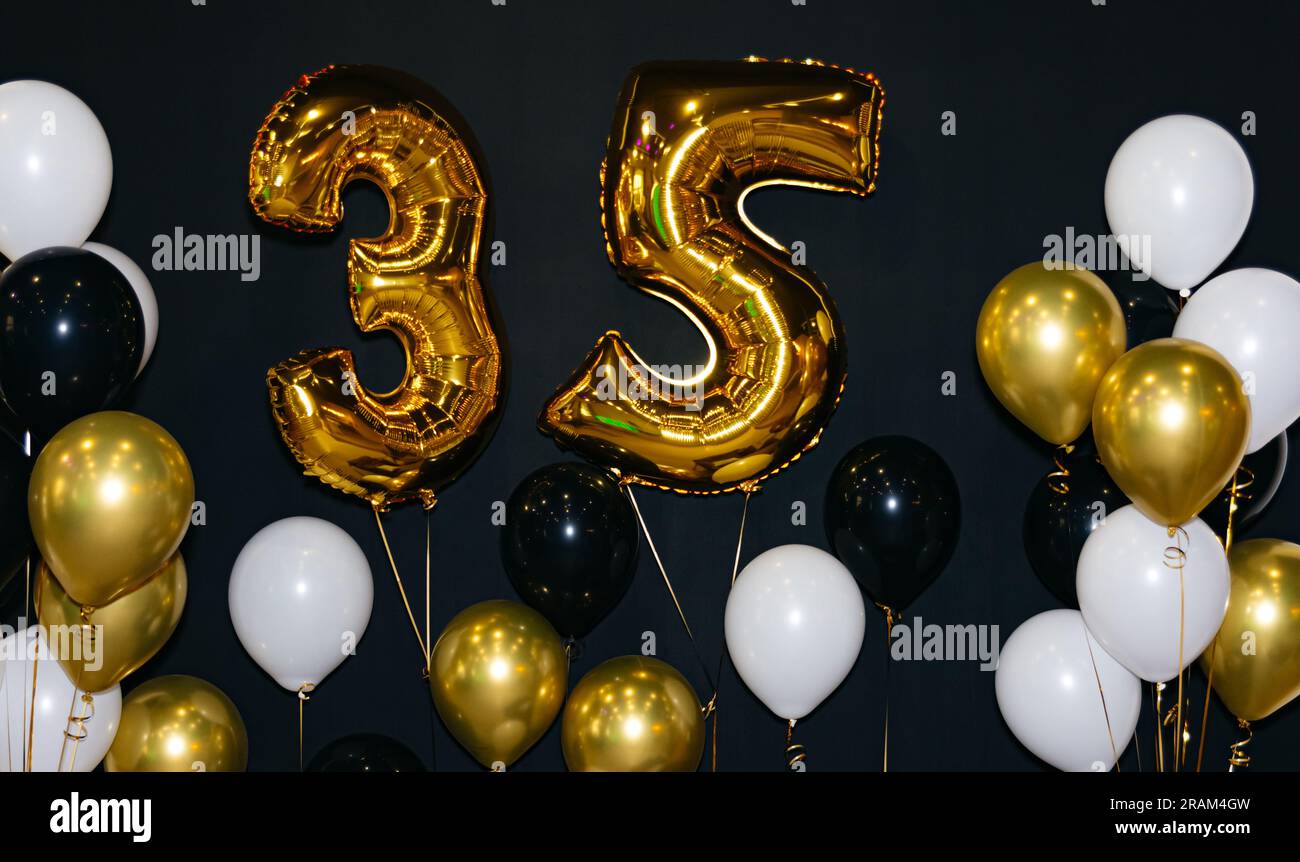 Festeggiamo i 35 anni con palloncini oro e nero. Una festa di compleanno  con decorazioni in nero e oro, con un gigantesco elio di 35 anni Foto stock  - Alamy
