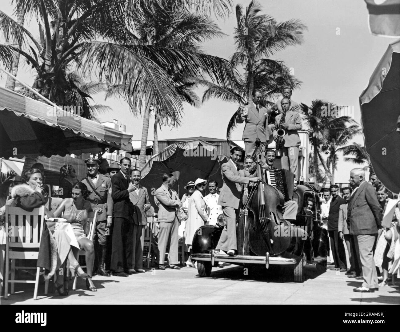 Miami, Florida: c. 1933. I clienti del Cafe de la Paix del Roney Plaza sono intrattenuti dai Meadowbrook Boys mentre navigano attraverso i gruppi di pranzo sul loro stand itinerante. Foto Stock