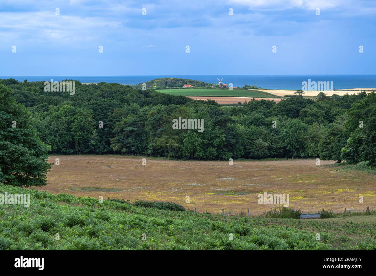 Una vista lontana che guarda al mare e al mulino a vento di Weybourne, North Norfolk, Regno Unito. Foto Stock