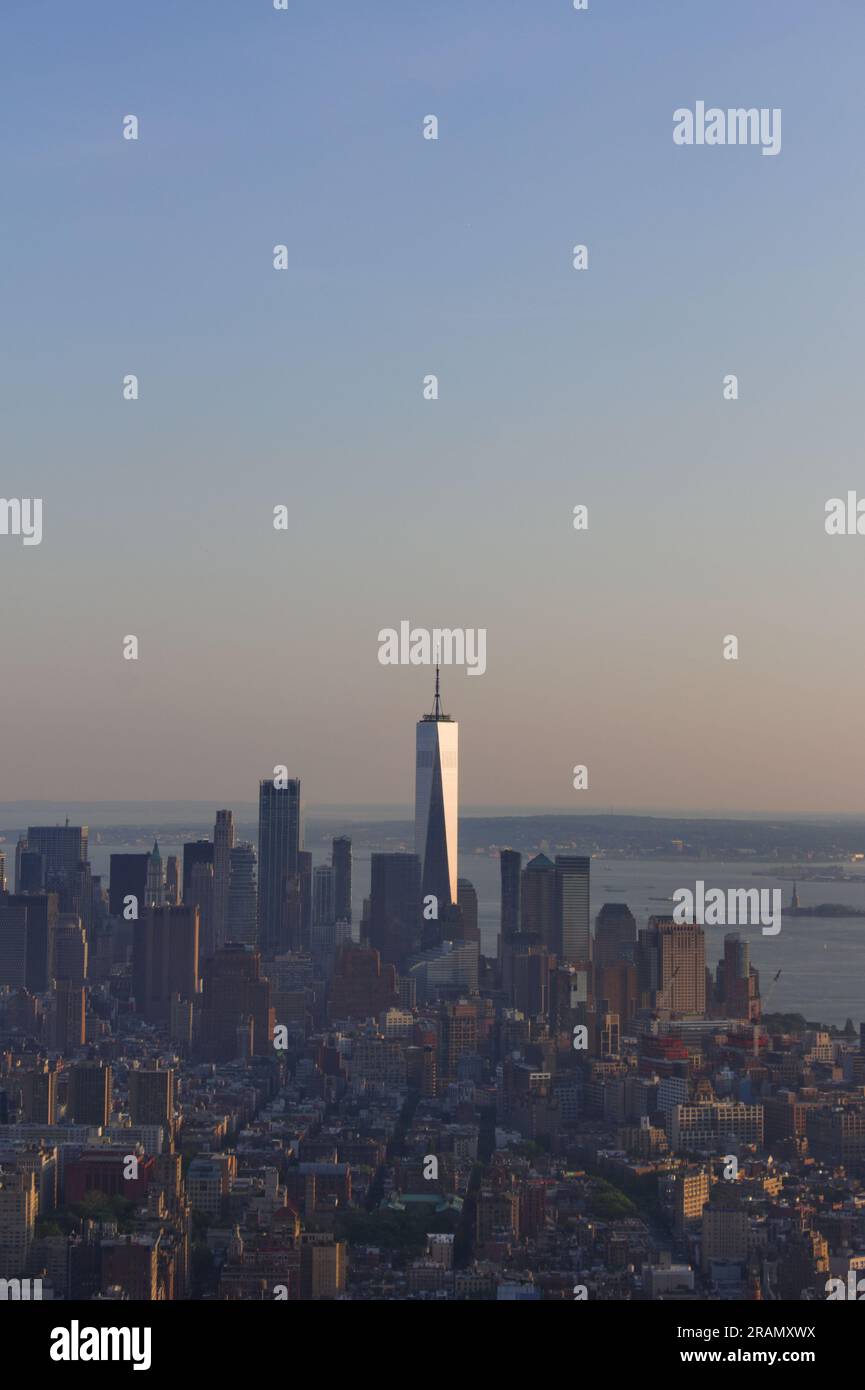 Il sole tramonta sullo skyline di Manhattan in una serata di mezza estate a New York City, New York. Foto Stock