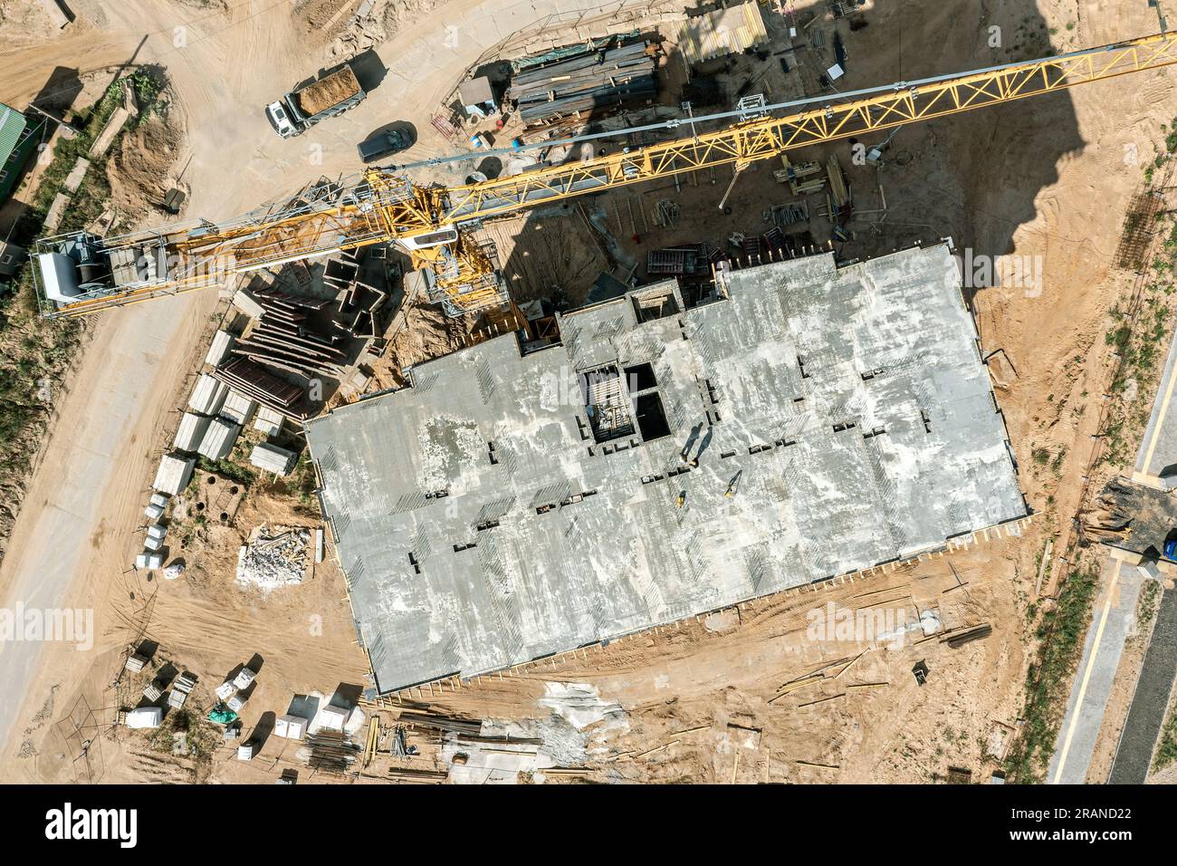 cantiere con gru, materiali edili e attrezzature pesanti. vista dall'alto dell'antenna. Foto Stock