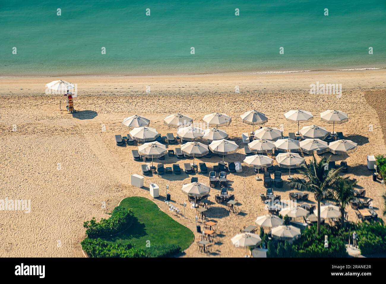 spiaggia con i turisti che si godono il sole e il mare, seduti sotto gli ombrelloni vista aerea dall'alto del timelapse. Foto Stock