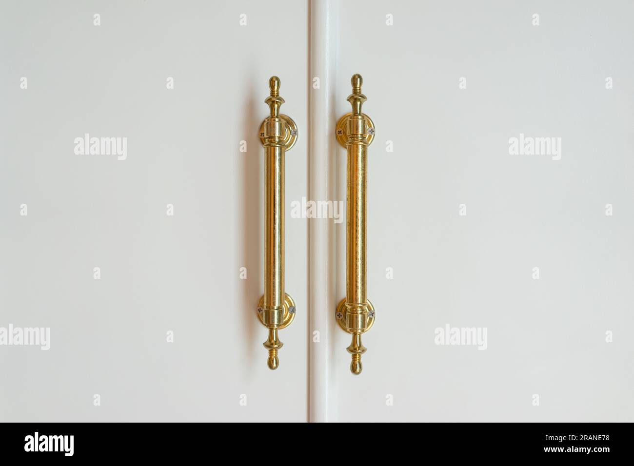 Maniglie in ottone dorato sulle porte bianche Foto Stock