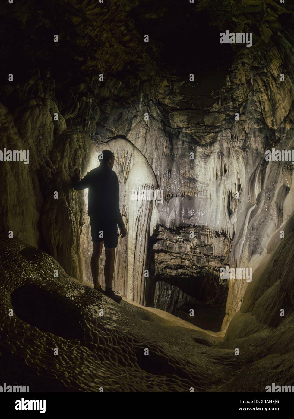 Uomo che esplora la misteriosa e naturale bellezza della Spar Cave sull'isola di Skye, in Scozia, in un affascinante viaggio sotterraneo Foto Stock