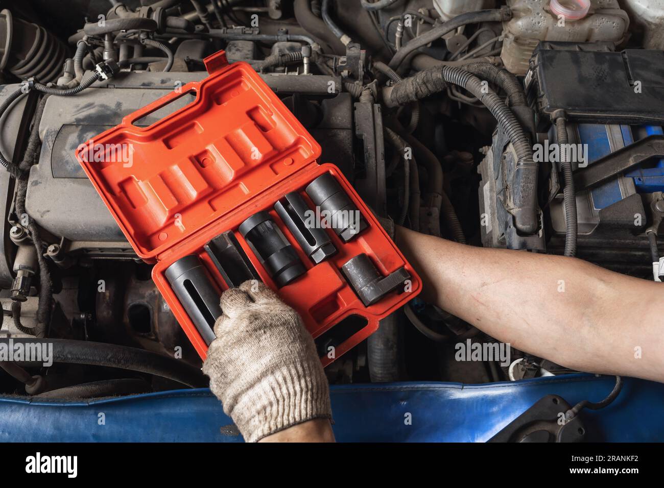 Il meccanico automatico sceglie uno strumento da un kit di manutenzione per auto Foto Stock