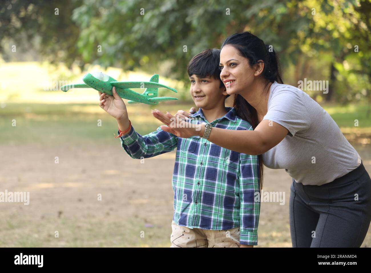 la famiglia si diverte in un parco. Stanno preparando il loro figlio e addestrandolo per un futuro migliore nello sport.cercando di far volare il bambino sull'aereo Foto Stock