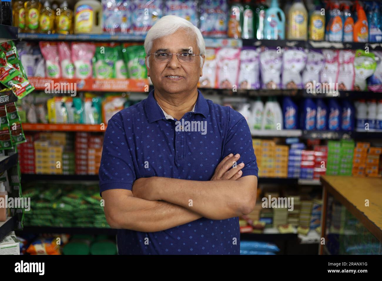 Ritratto di un anziano indiano felice e sorridente che acquista in un negozio di alimentari. Nonno sicuro e in forma che acquista generi alimentari per casa in un supermercato. Foto Stock