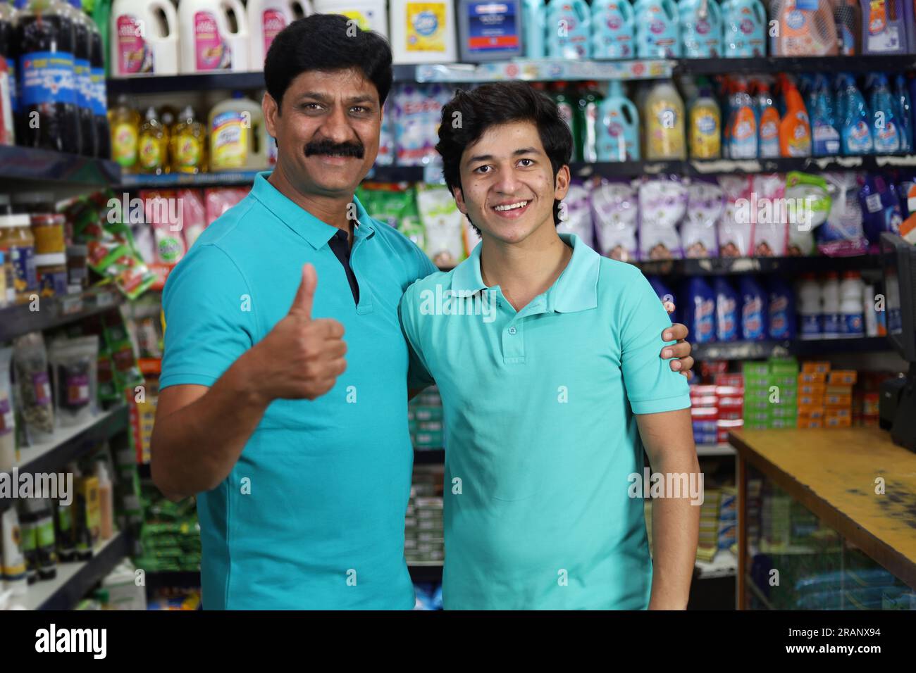 Padre e figlio che acquistano in un negozio di alimentari. Comprare della spesa per casa in un supermercato. Padre e figlio allegri che tengono un prodotto in mano in un centro commerciale. Foto Stock