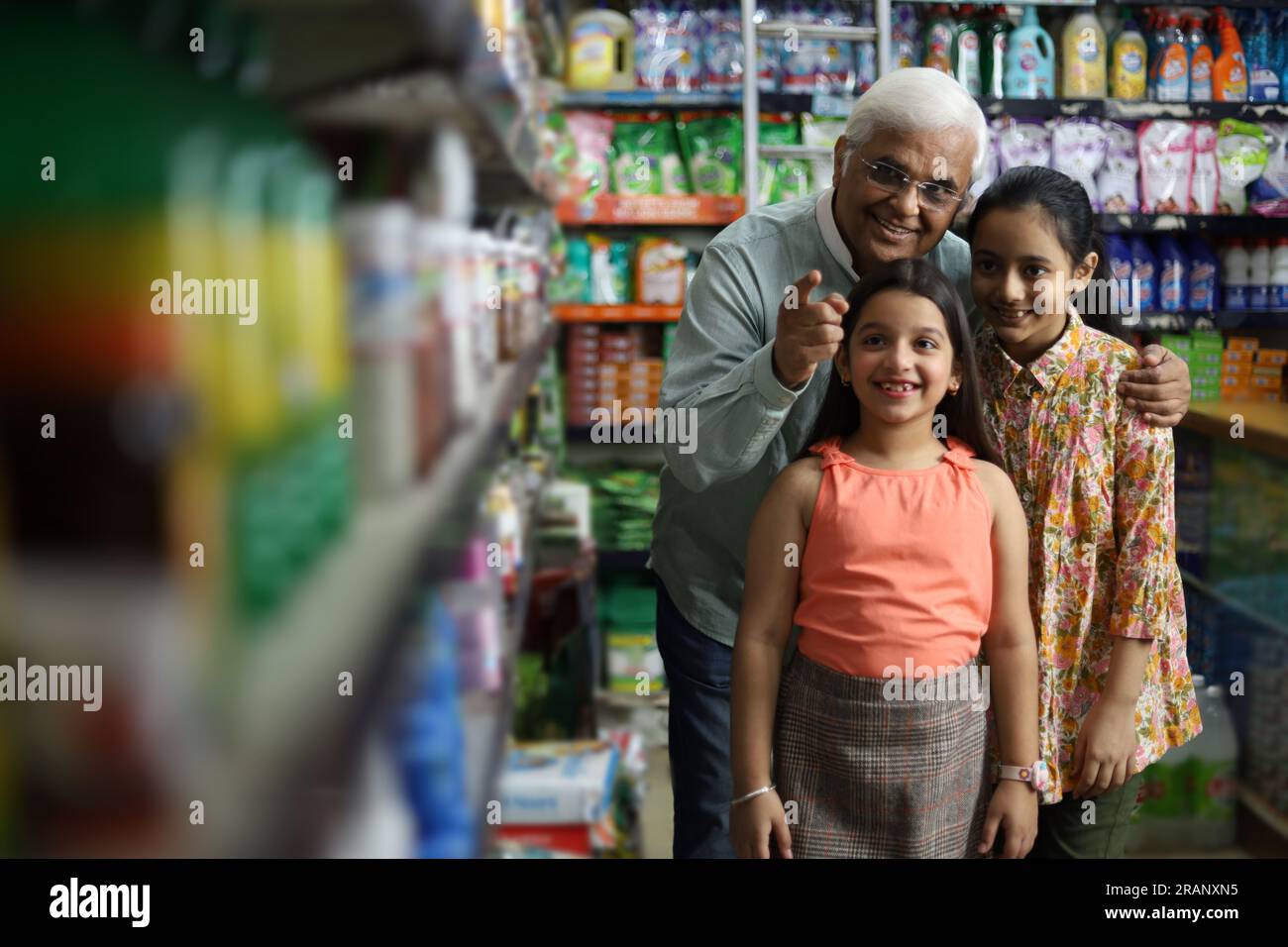 Buon nonno e le nostre nipoti si divertono ad acquistare in un negozio di alimentari. Comprare della spesa per la casa al supermercato. Le nipoti sono felici con il nonno Foto Stock