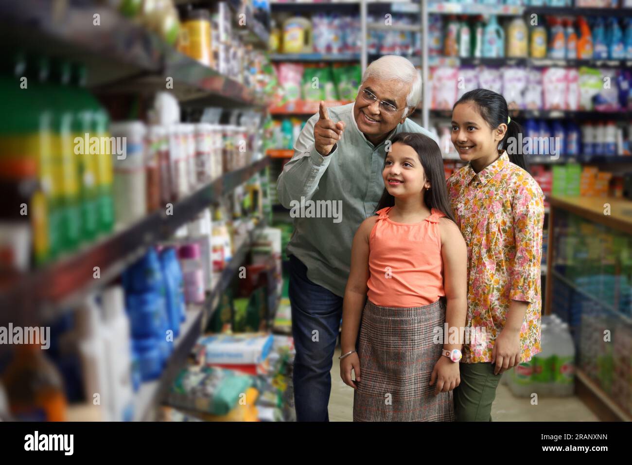 Buon nonno e le nostre nipoti si divertono ad acquistare in un negozio di alimentari. Comprare della spesa per la casa al supermercato. Le nipoti sono felici con il nonno Foto Stock