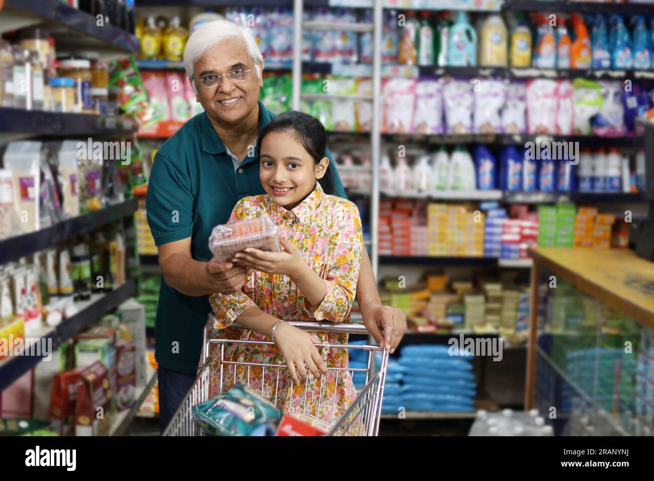 Felice nonno e nipote che si divertono ad acquistare in un negozio di alimentari. Comprare della spesa per casa in un supermercato. Foto Stock