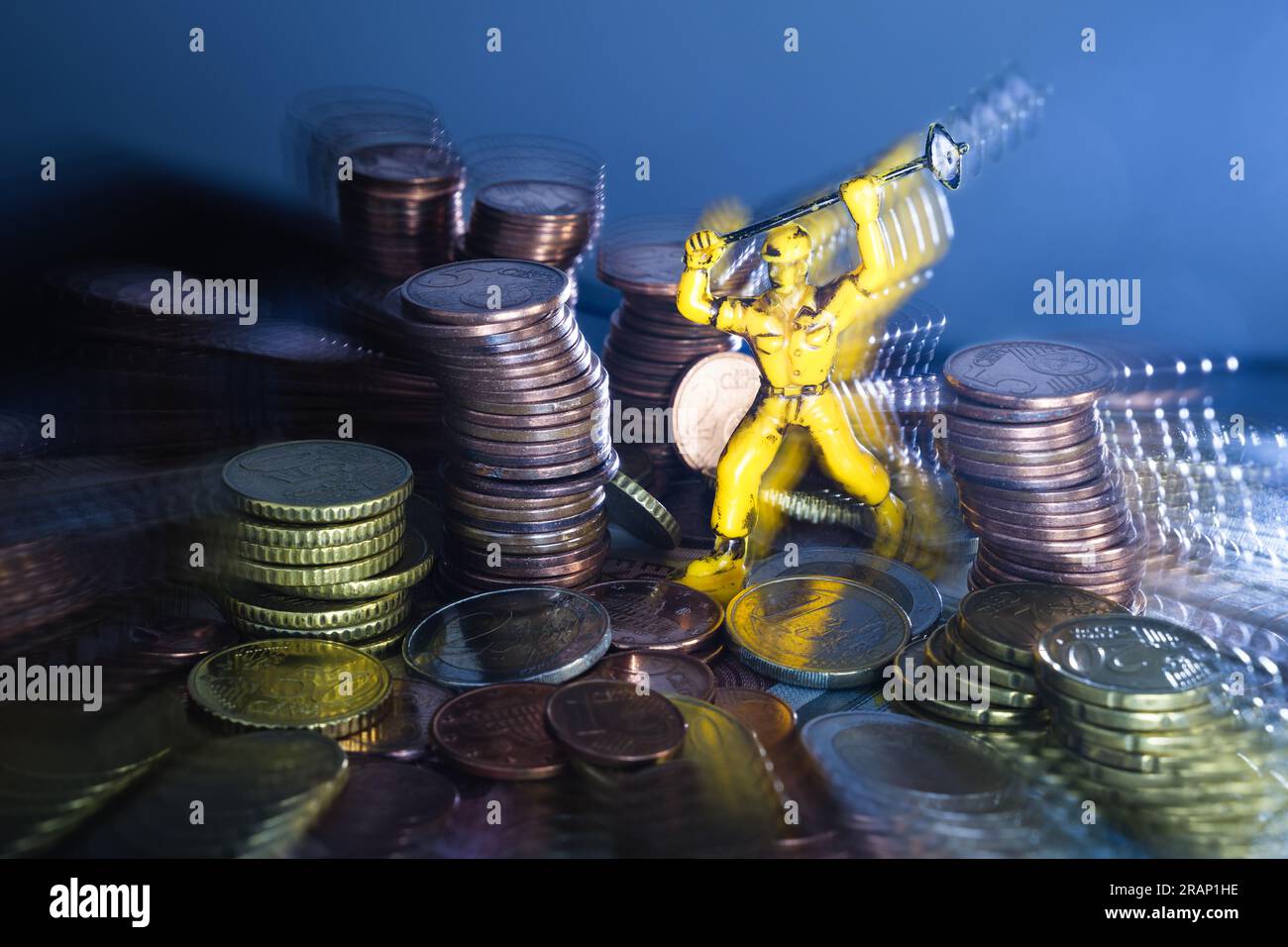 Composizione creativa, molte monete Euro colpite da un piccone giocattolo, tecnica fotografica del movimento. Foto Stock
