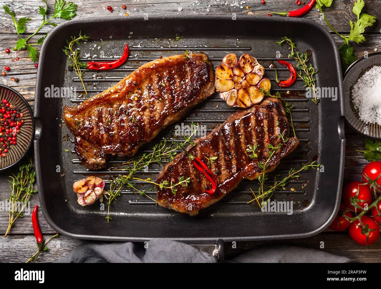 Bistecca di striploin alla griglia con spezie ed erbe sulla teglia di ferro. La bistecca di strip, chiamata anche striscia di New York. Foto Stock