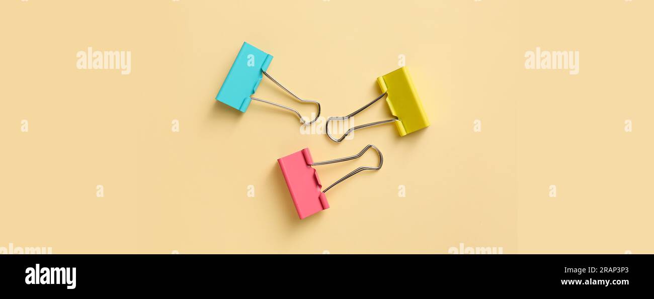 Clip colorate per la carta su sfondo beige Foto Stock