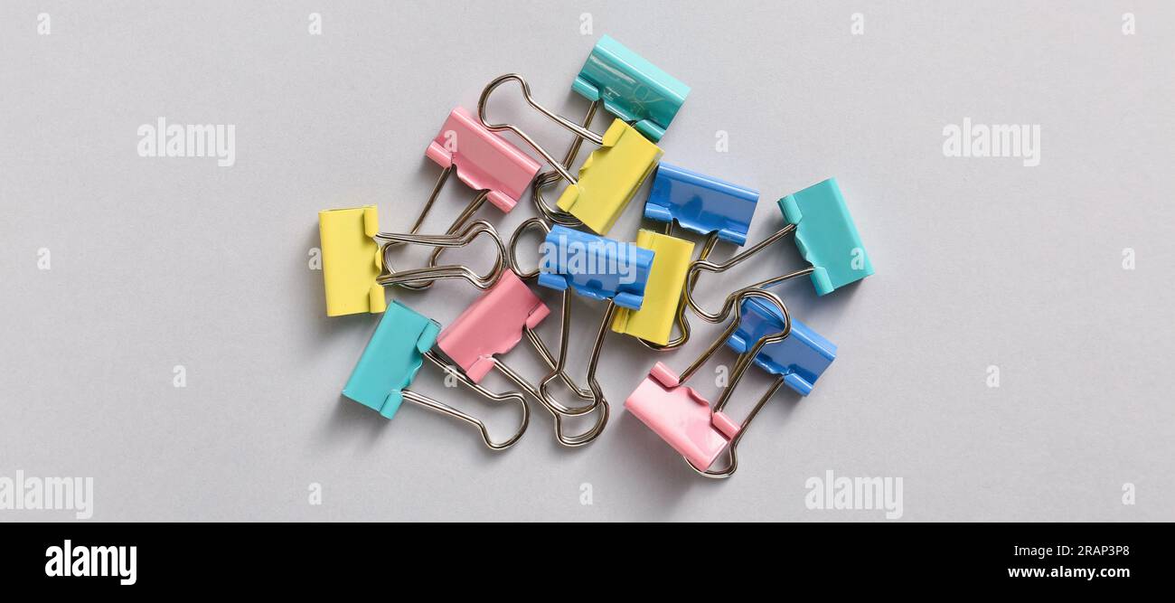 Clip Binder colorate su sfondo grigio Foto Stock