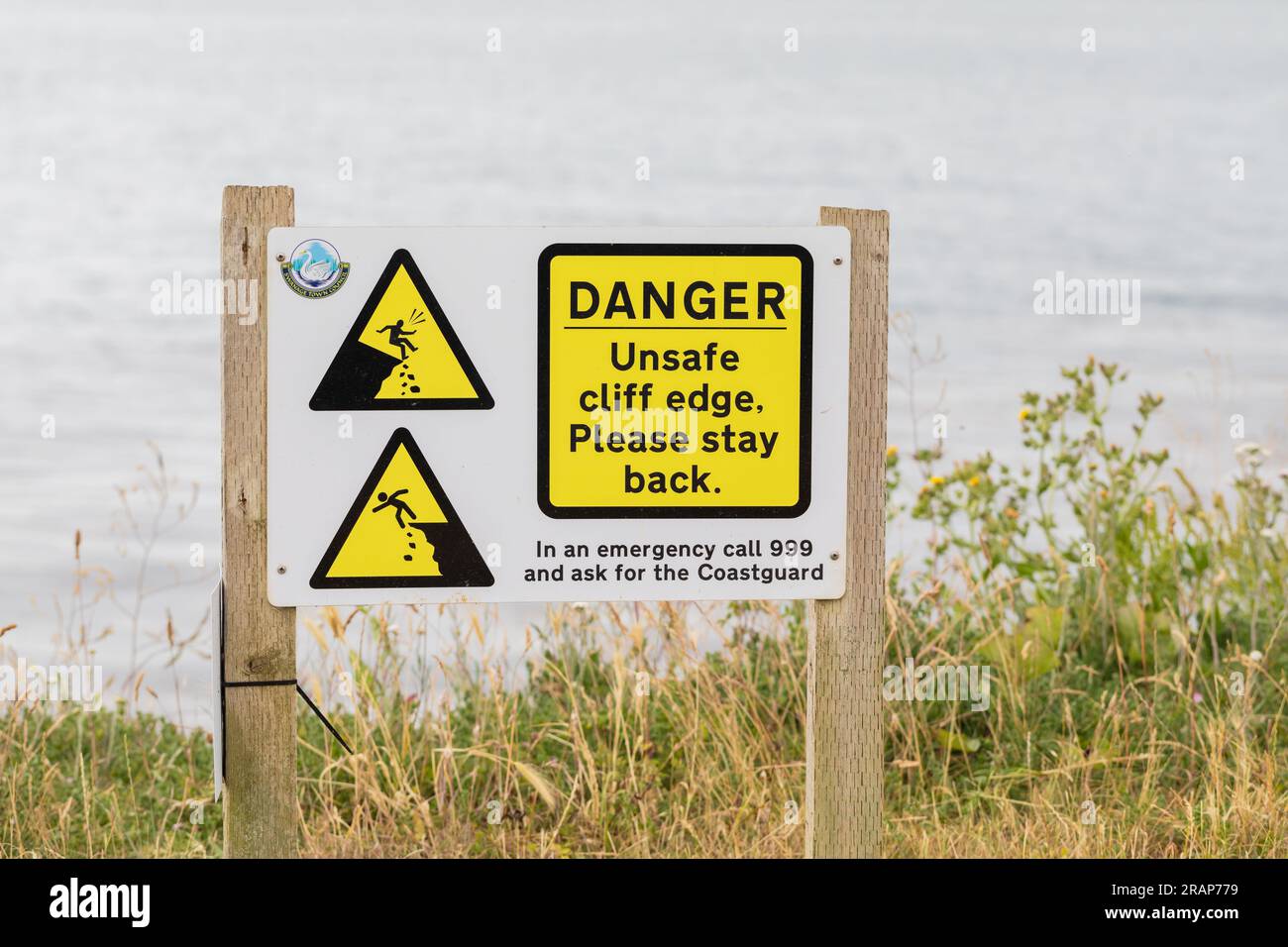 Cartello di pericolo per bordo scogliera non sicuro. Swanage, Dorset, Regno Unito Foto Stock
