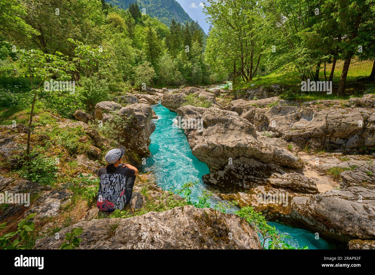 Donna che riposa durante un tour escursionistico lungo il turchese fiume Soca nel Parco Nazionale del Triglav delle Alpi Giulie in Slovenia Foto Stock
