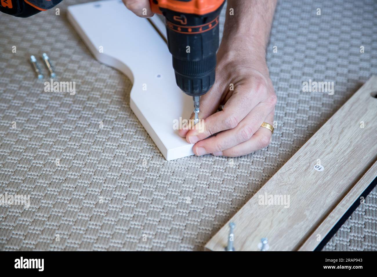 Dettagli fai-da-te in interni. Persona che segue i passaggi per costruire una struttura in legno MDF. Immagine ravvicinata. Foto Stock
