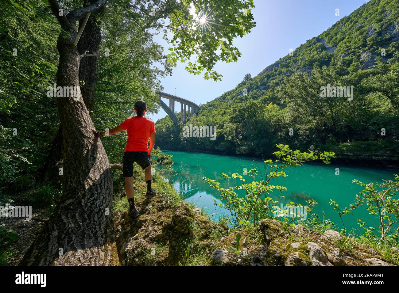 Donna che riposa durante un tour escursionistico lungo il turchese fiume Soca nel Parco Nazionale del Triglav delle Alpi Giulie in Slovenia Foto Stock