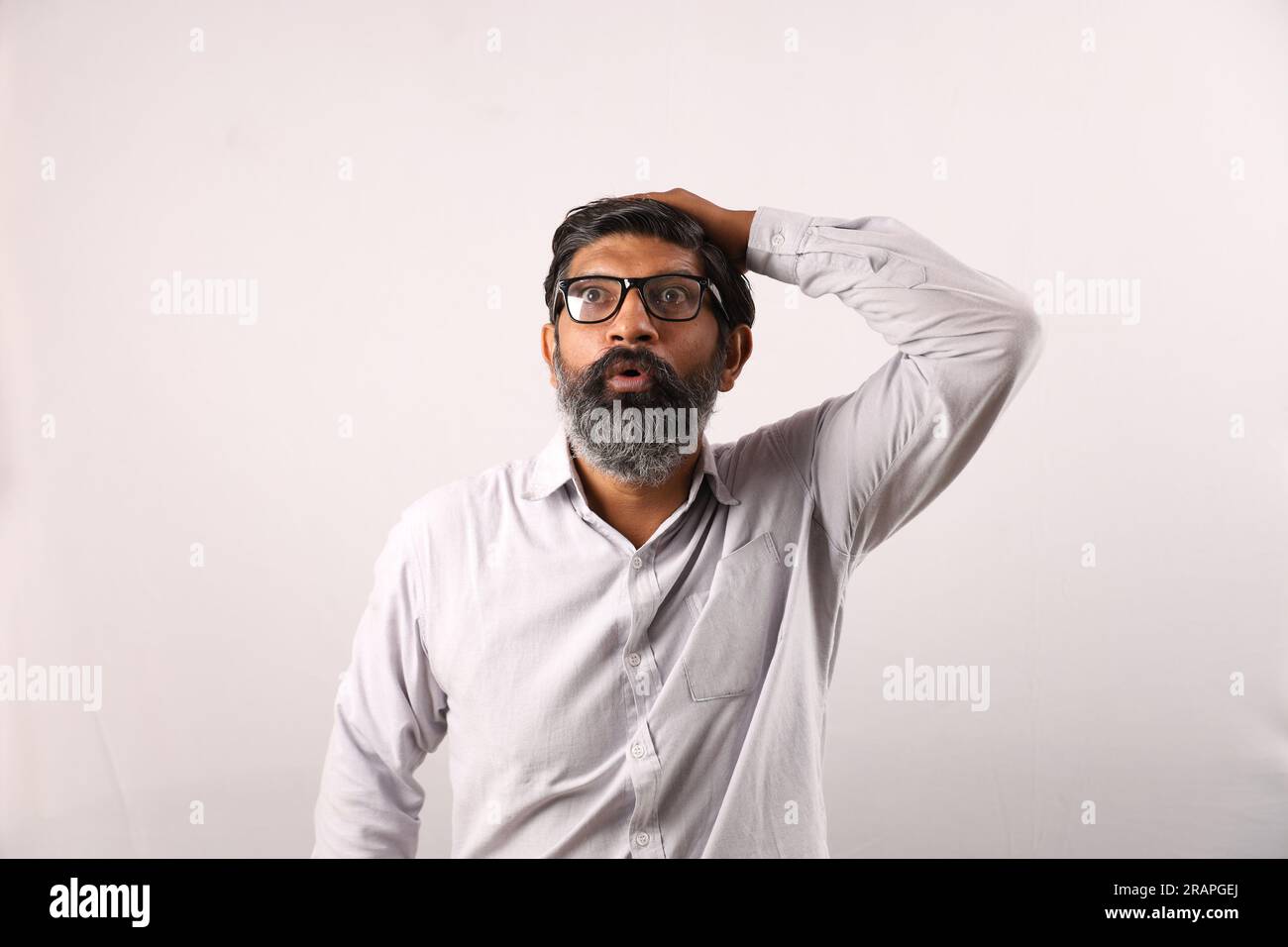 Ritratto di un uomo barbuto indiano che indossa una camicia. Espressioni funky tristi e sgradevoli, piene di dolore e di rammarico. Angoscia disperazione uomo scontento. Foto Stock