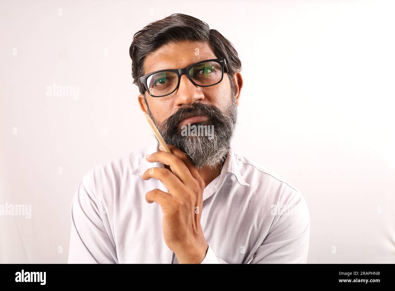 Ritratto di un uomo barbuto indiano che indossa una camicia. Espressioni funky tristi e sgradevoli, piene di dolore e di rammarico. Angoscia disperazione uomo scontento. Foto Stock