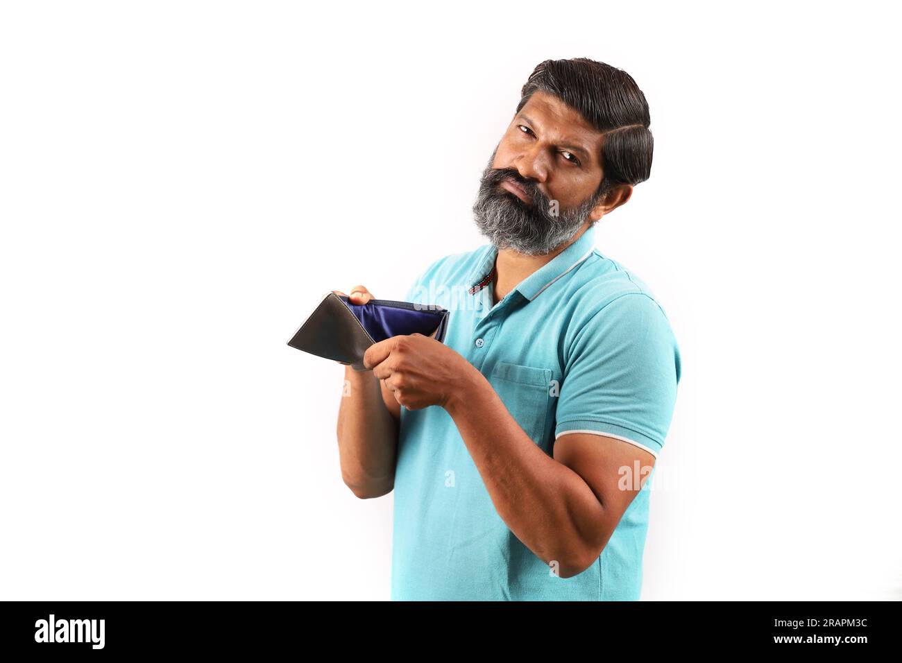 Ritratto di un uomo indiano barbuto che indossa una camicia con un portafoglio vuoto. Espressioni Wacky e Funky sfondo bianco. povertà e niente soldi e niente soldi. Foto Stock