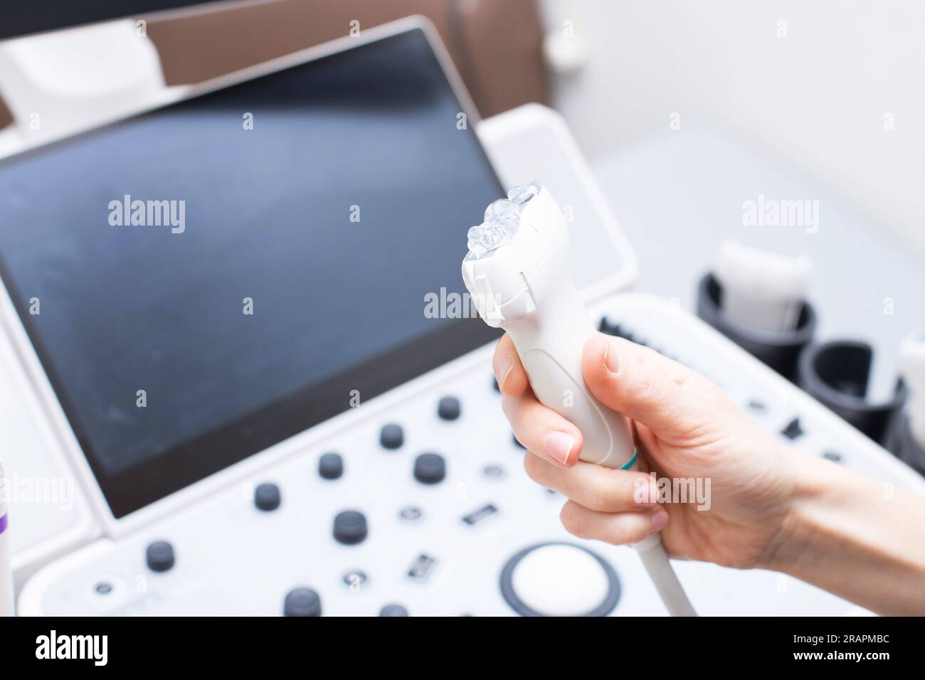 Mano del medico della donna che astiuta un gel medico al sensore ultrasonico della macchina ultrasonica nella clinica. Diagnostica di scansione a ultrasuoni. assistenza sanitaria a. Foto Stock