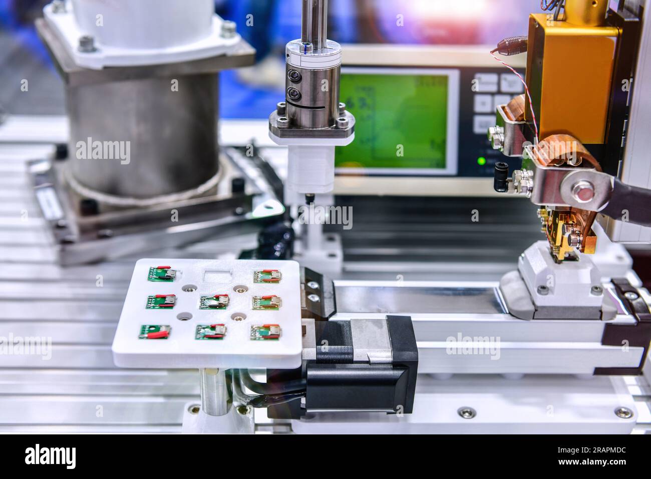 Macchinari di fabbrica al lavoro, Una piccola scheda a circuito stampato viene assemblata in un braccio robotico automatizzato Foto Stock