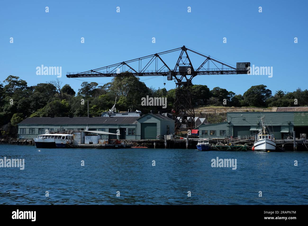 Gru e officine di riparazione e ingegneria marina a Goat Island, viste dall'acqua sul porto di Sydney. Foto Stock