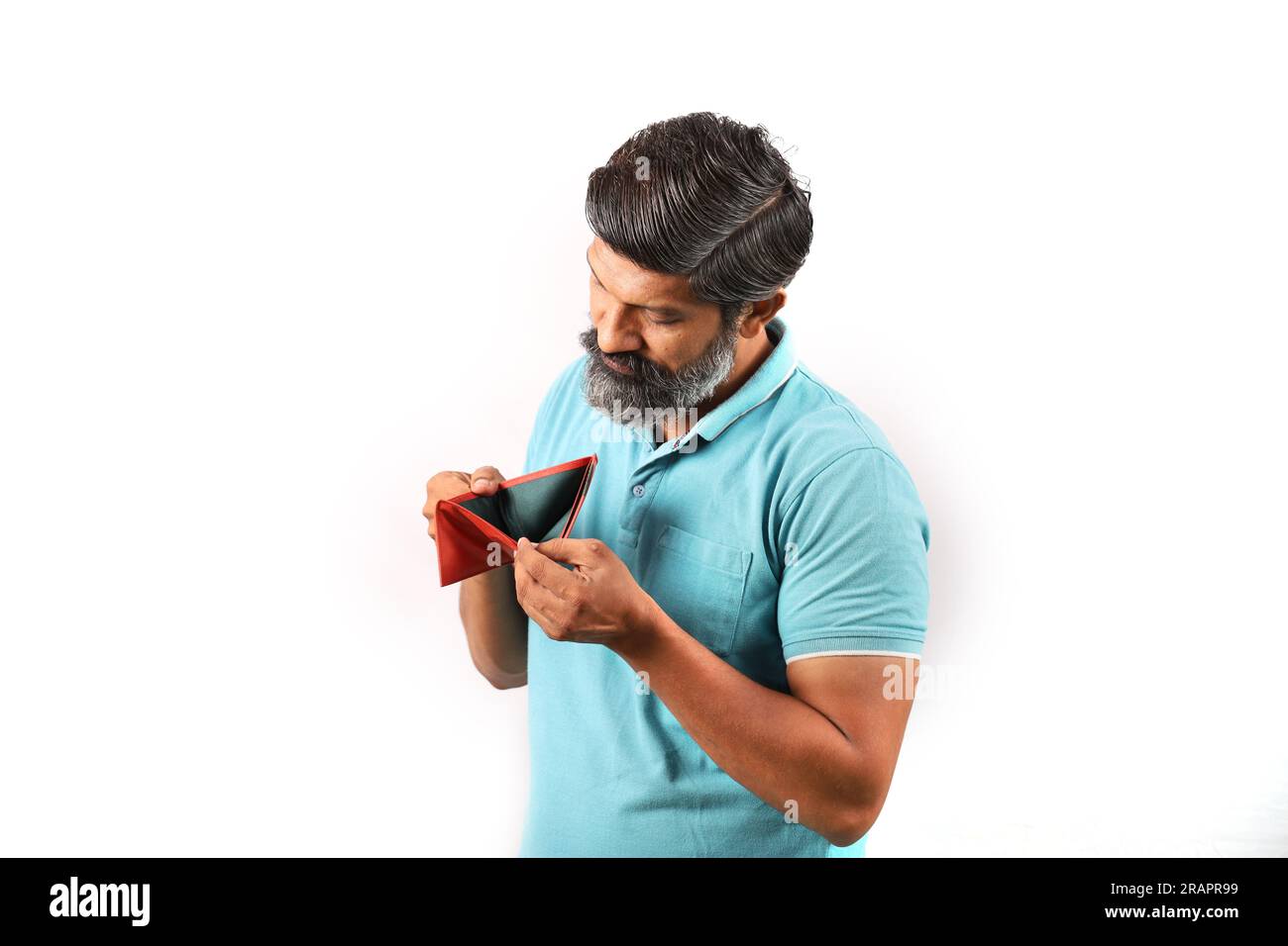 Ritratto di un uomo indiano barbuto che indossa una camicia con un portafoglio vuoto. Espressioni Wacky e Funky sfondo bianco. povertà e niente soldi e niente soldi. Foto Stock