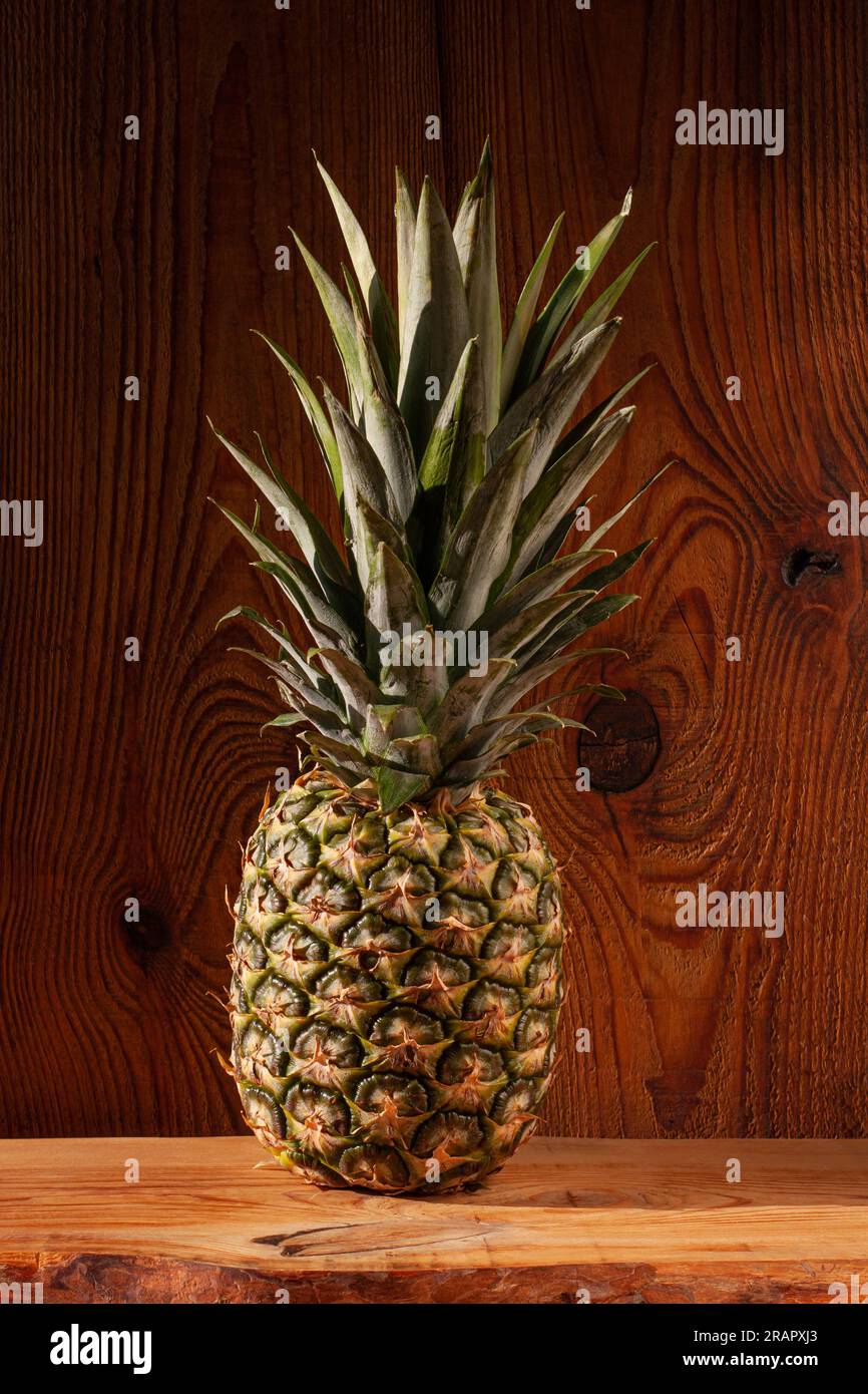 Ananas maturo su fondo di legno. Ingredienti alimentari sani, frutta tropicale, dieta, dimagrimento degli alimenti vegani, perdita di peso. Stile minimalista, vista frontale, ve Foto Stock