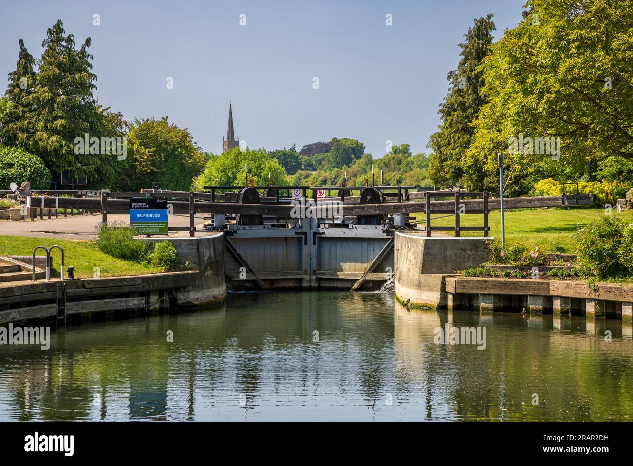 La chiusa di San Giovanni sul Tamigi con la guglia della chiesa di San Lorenzo a Lechlade, Gloucestershire / Oxfordshire, Inghilterra Foto Stock