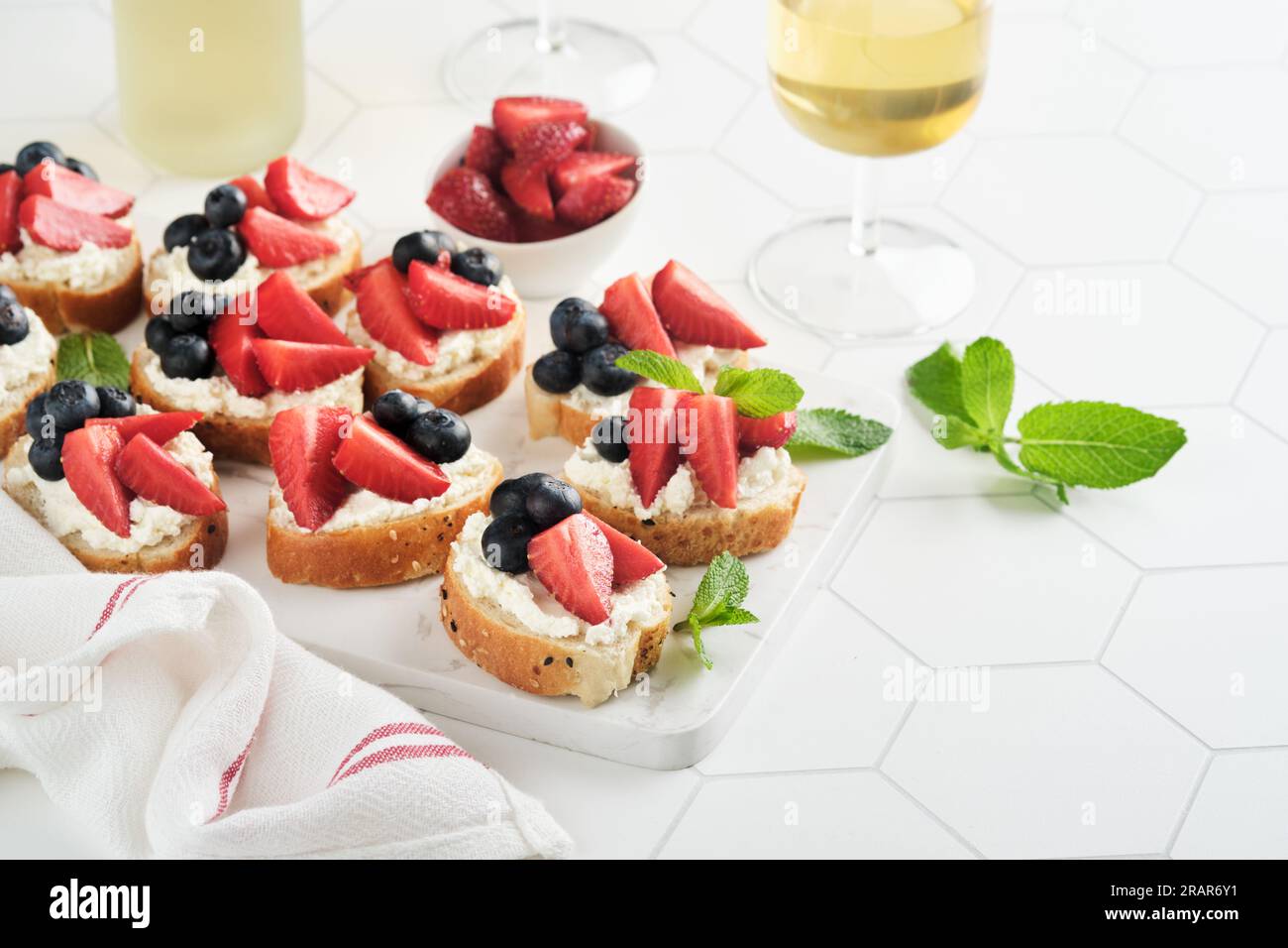 Panino con bandiera americana con fragole, mirtilli, panna dolce montata, formaggio morbido su pane tostato. 4 luglio cibo per il giorno dell'indipendenza americana. In Foto Stock