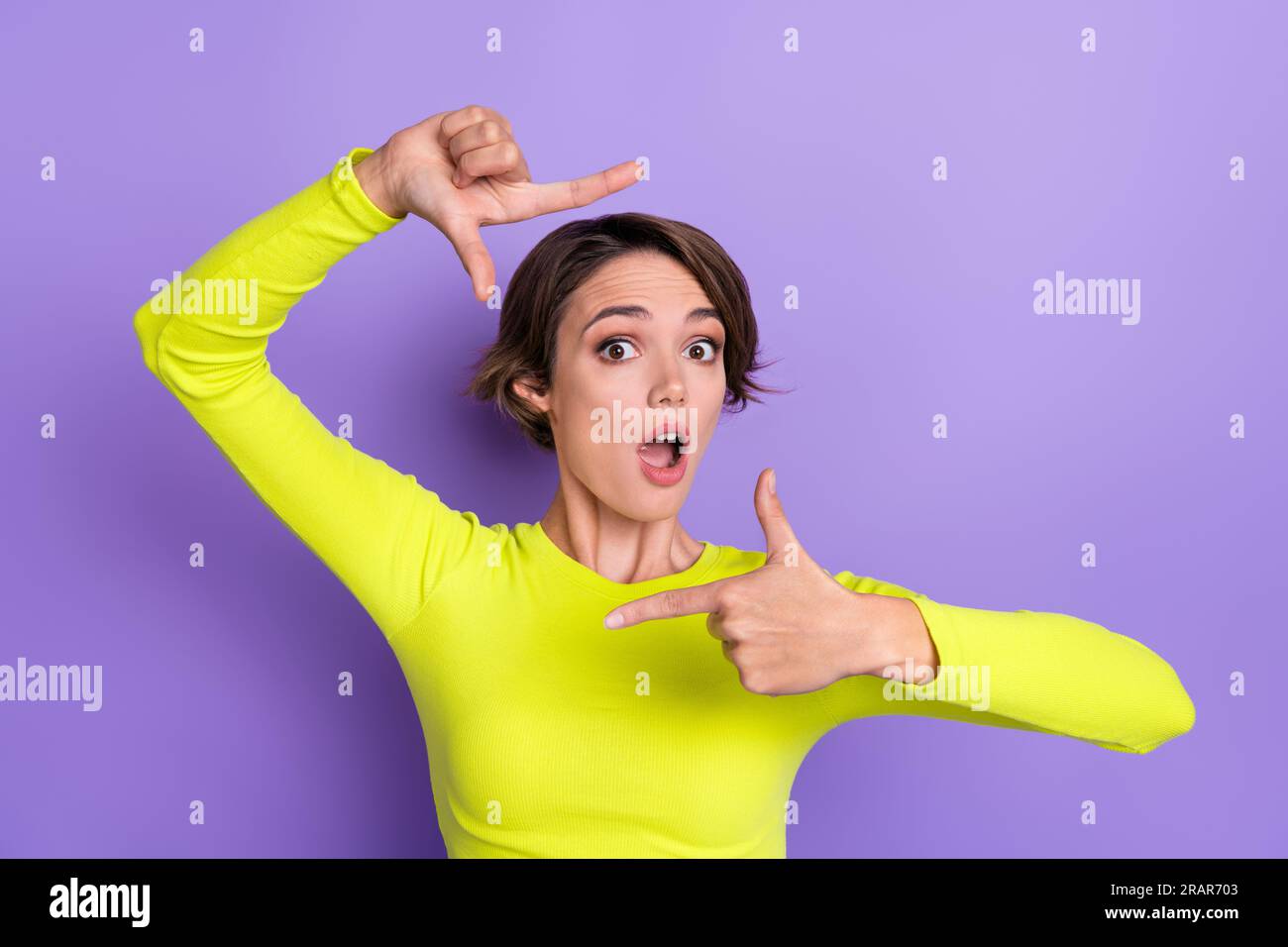 Ritratto di persona impressionata le dita delle braccia mostrano il gesto del quadro bocca aperta isolata su sfondo viola Foto Stock