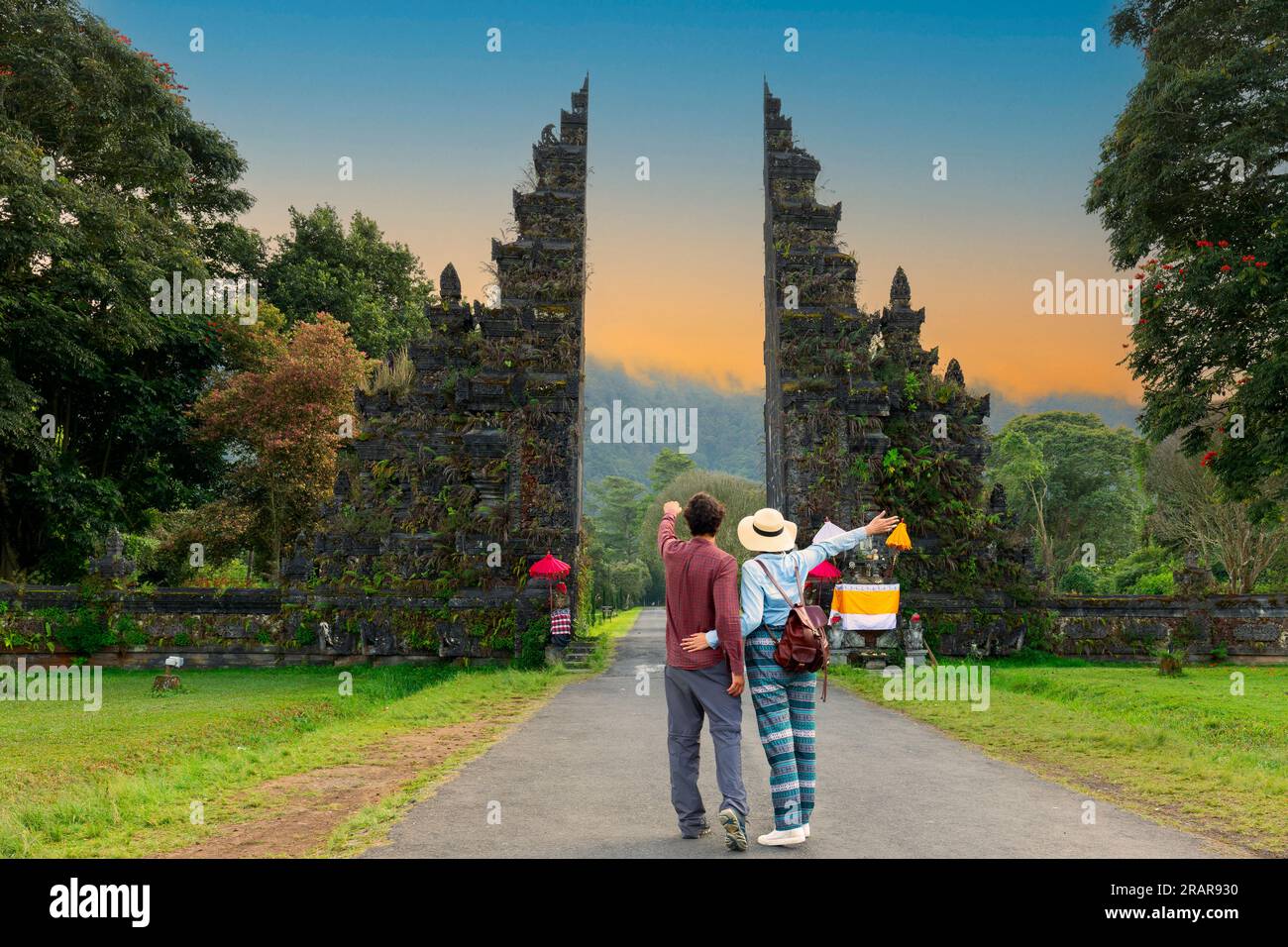 Felice coppia in vacanza a piedi attraverso il tempio indù di Bali, Indonesia, porta di Handara. Foto Stock