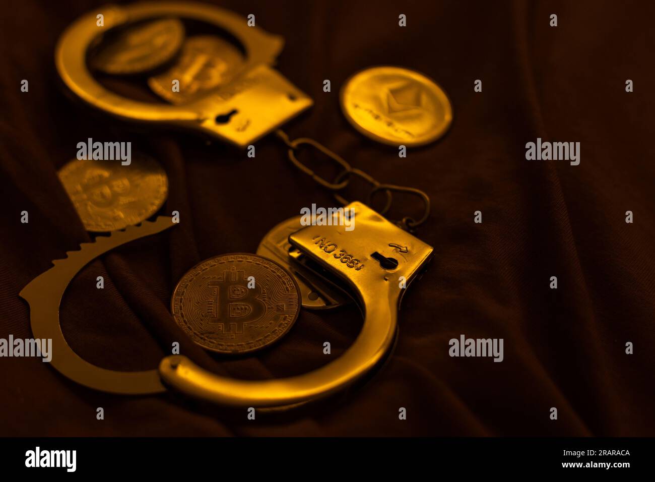 Criptovaluta Golden Bitcoins con manette sulle fatture in dollari. Concetto di criminalità digitale, arresto o hacking. Manette dollari e bitcoins sul tavolo Foto Stock