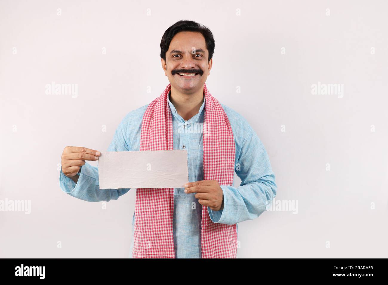 Ritratto di un felice agricoltore indiano nel concetto rurale dell'India. Su uno sfondo bianco, l'allegro agricoltore sta dando un'azione mozzafiato e si sente orgoglioso Foto Stock