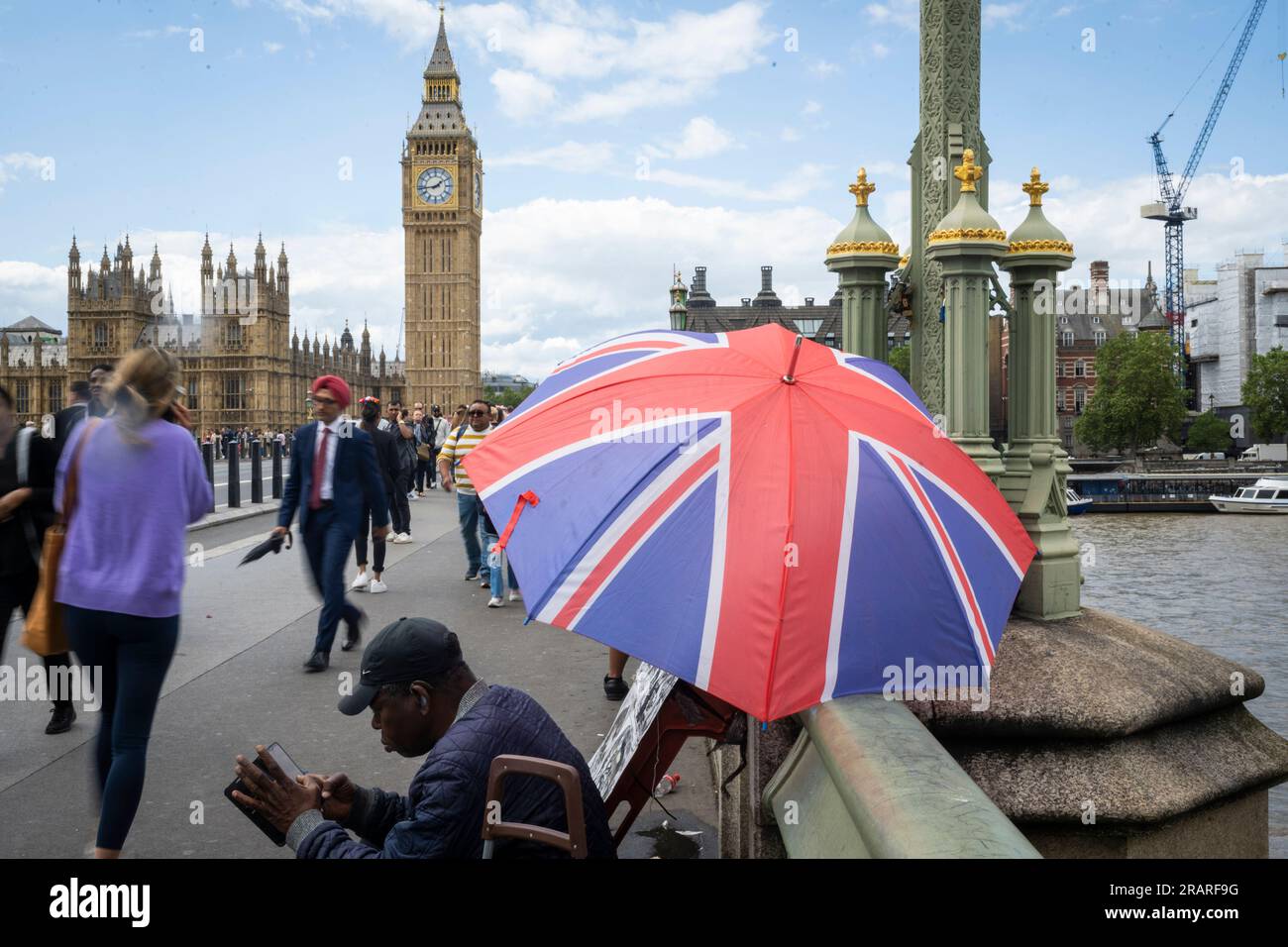 Londra, Regno Unito. 5 luglio 2023. I turisti passano un ombrello Union Jack sul Westminster Bridge. L'Organizzazione per la cooperazione e lo sviluppo economico (OCSE) ha riferito che il Regno Unito è ora l'unico paese del gruppo G7 di nazioni ricche che ancora affrontano l'inflazione in aumento. L'inflazione nel Regno Unito è salita al 7,9% a maggio, in aumento dal 7,8% di aprile, mentre tra i paesi del G7 il tasso è sceso al 4,6%, in calo dal 5,4%. Crediti: Stephen Chung / Alamy Live News Foto Stock