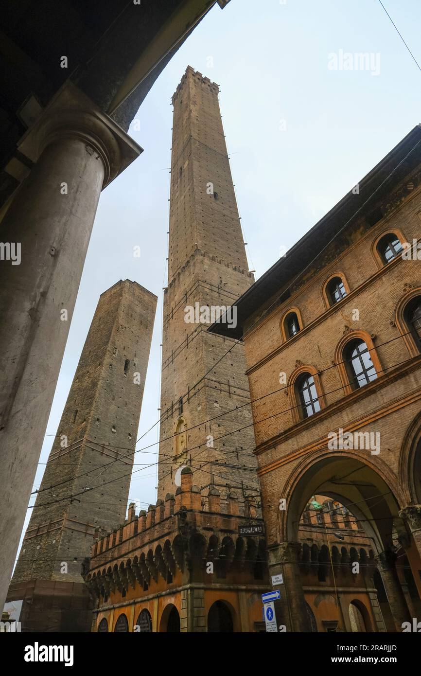 Bologna, Italia: Torre Asinelli, due torri nel centro storico della città attraverso il cielo nuvoloso, mete di viaggio Foto Stock