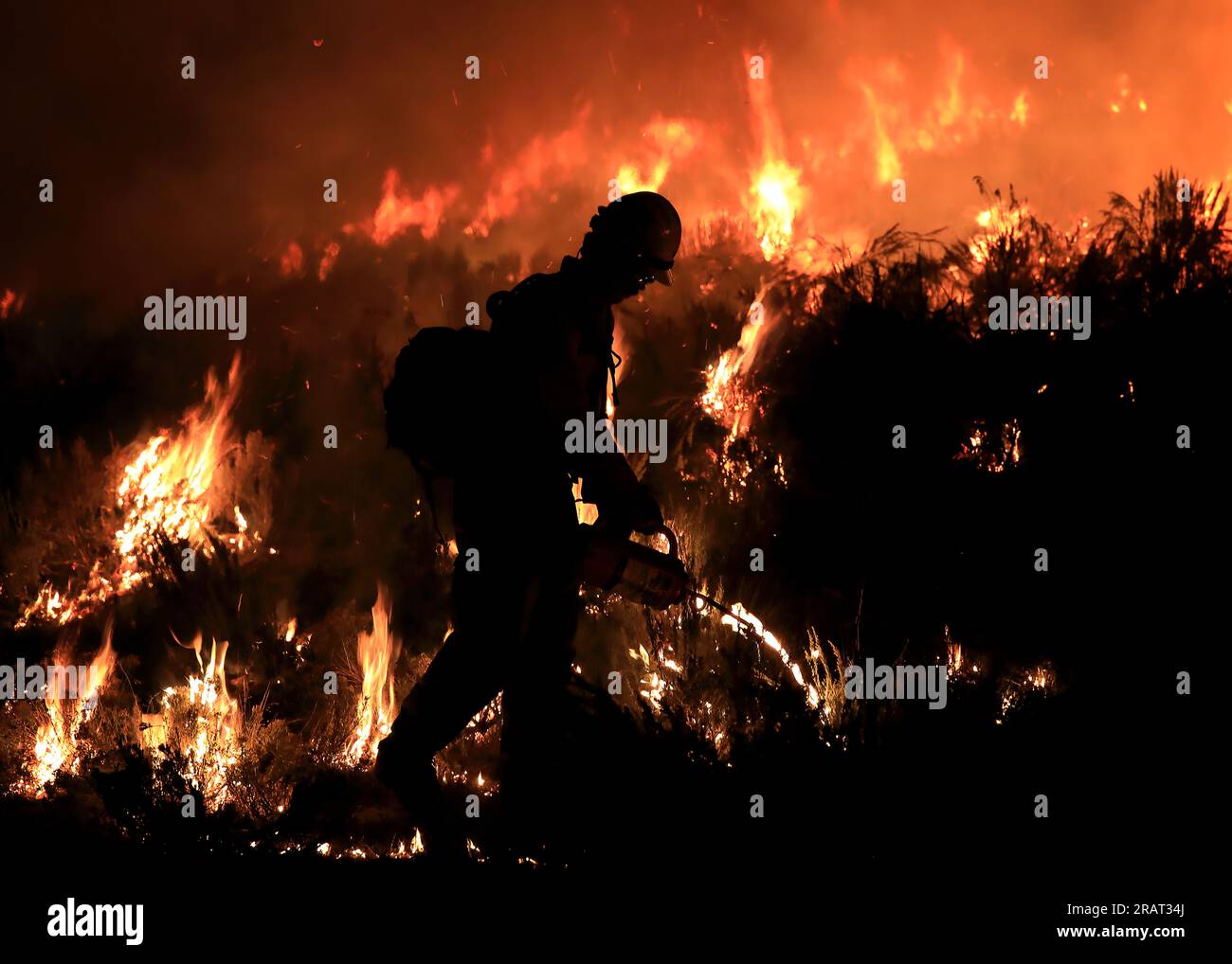 Un vigile del fuoco conduce operazioni di tiro di notte sul fuoco di Sagehen del 2022 vicino a Blackfoot, Idaho. Foto di Austin Catlin, BLM Foto Stock