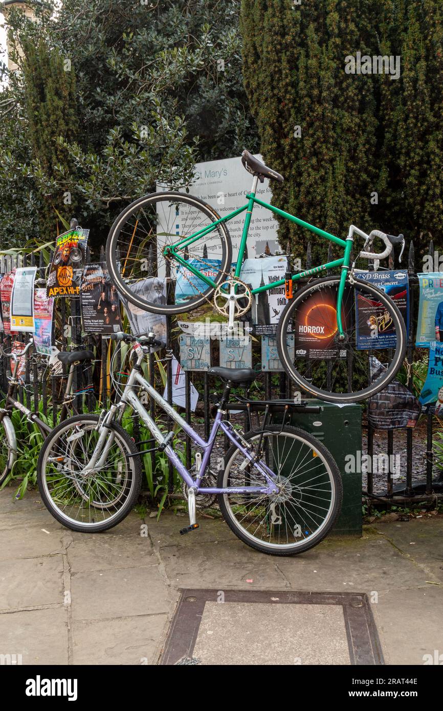 Una carenza di stand per biciclette ha portato una bicicletta a essere rinchiusa nelle ringhiere sopra un'altra bicicletta, Market Square, Cambridge, Regno Unito. Foto Stock